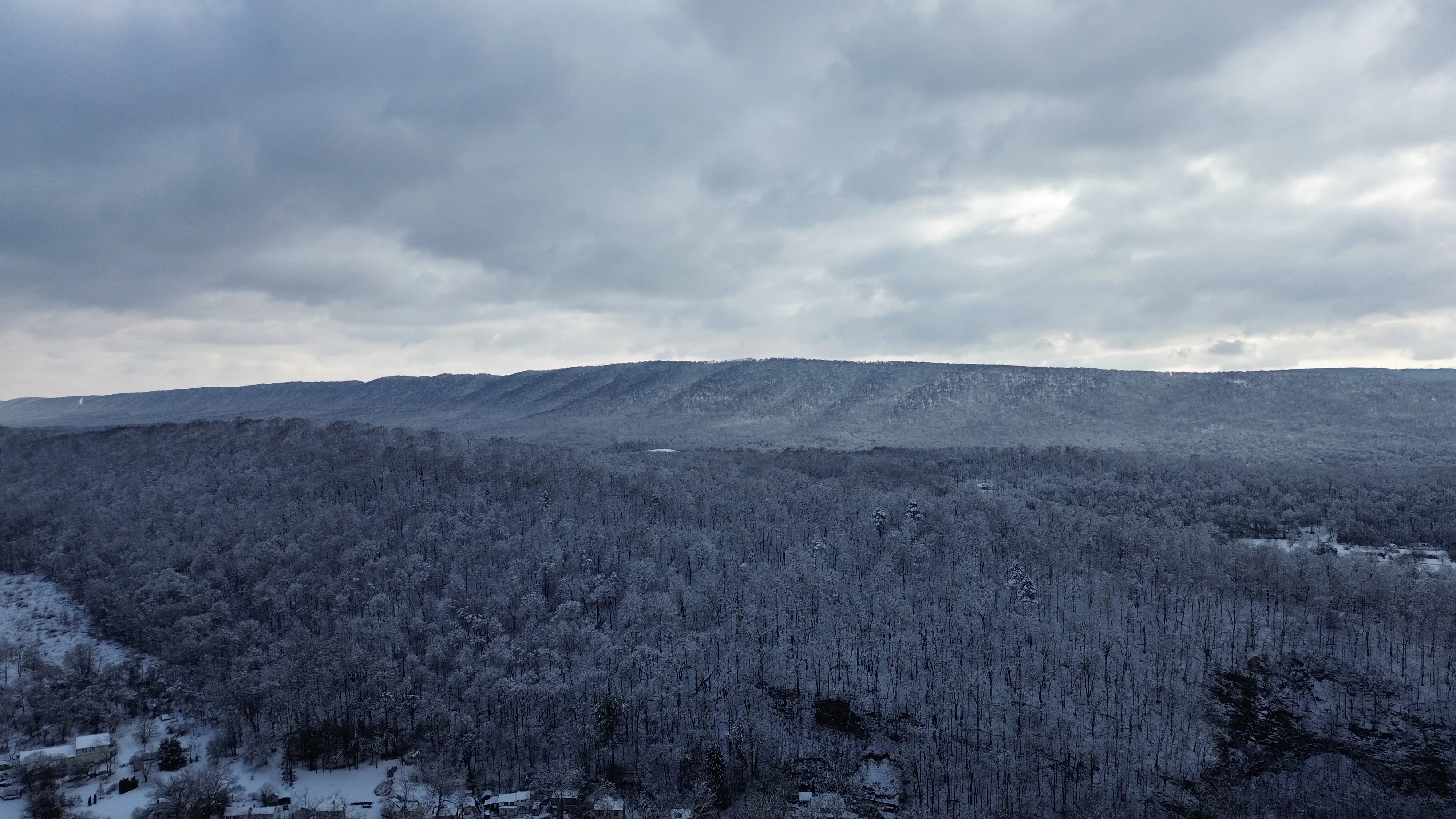 Snow-covered ridge under a heavy gray winter sky.
